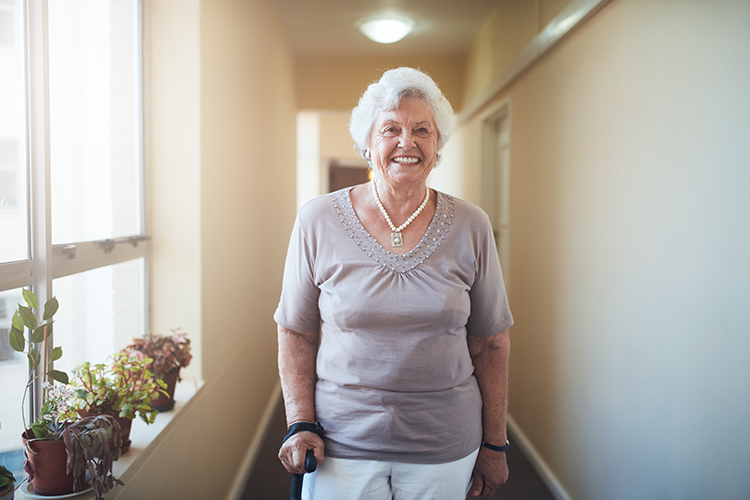 Personne aînée debout et souriante